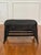 Shapely French natural wicker coffee table with a lower shelf in a black painted finish, circa late 1960-70s. It features...