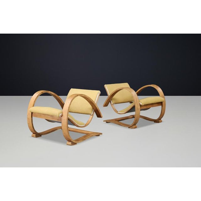 This rare pair of lounge chairs embodies the refined craftsmanship and sculptural elegance of French Art Deco design from...