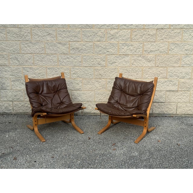 Pair of vintage Scandinavian Modern lounge chairs, circa 1970s. Each features a sculptural bent wood frame with a...