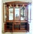 This piece features a traditional silhouette with a prominent medallion crown and a warm hardwood finish. The upper hutch...