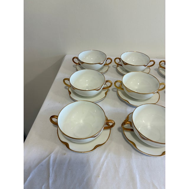 An elegant set of 9 antique Haviland & Co. Limoges double-handled bouillon cups with matching saucers, finished with hand-...