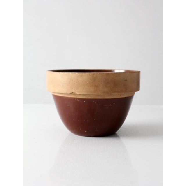 Antique stoneware mixing bowl with a classic, substantial form and a warm, grounded presence. The wide banded rim in soft...