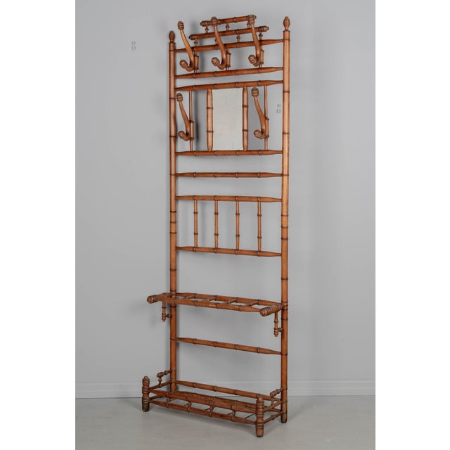 A 19th century French faux bamboo hall tree with small mirror and six large hooks for coats and hats. Made of beech wood...