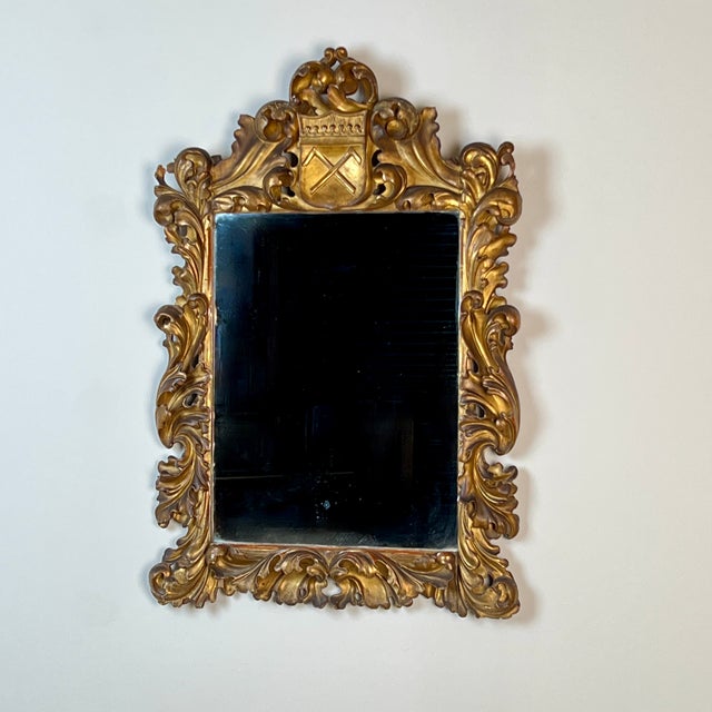 A 19th-Century Continental Armorial Giltwood Wall Mirror Of good proportions and colour, the mirror features a beautifully...