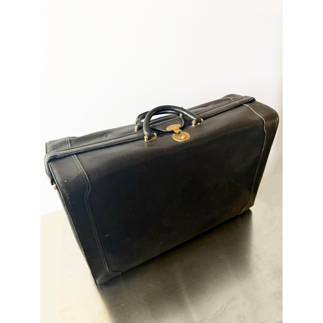 Iconic black leather Gucci suitcase ca. 1960s. Scuffs and wear throughout, great shape for its age. Original brass...