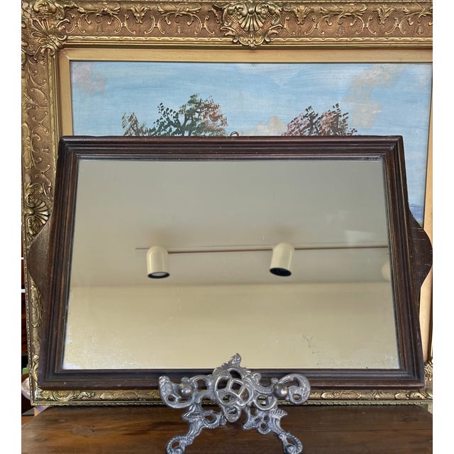 This likely early 20th-century Arts and Crafts wall mirror features what appears to be a solid wood frame with a hand-...
