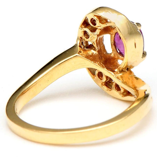 The swirl pattern on this 14K yellow gold ruby and diamond swirl ring perfectly showcases the central oval-shaped gemstone...