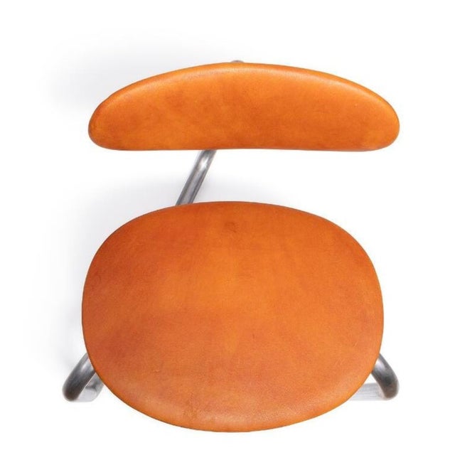 Pair of lounge chairs with tubular steel frame and patinated leather. Designed by Erik Magnussen for Kevi. Made in Denmark...