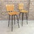 A pair of vintage Mid Century Modern swivel bar stools with walnut wooden slat seat, wrought iron chair frame and chrome...