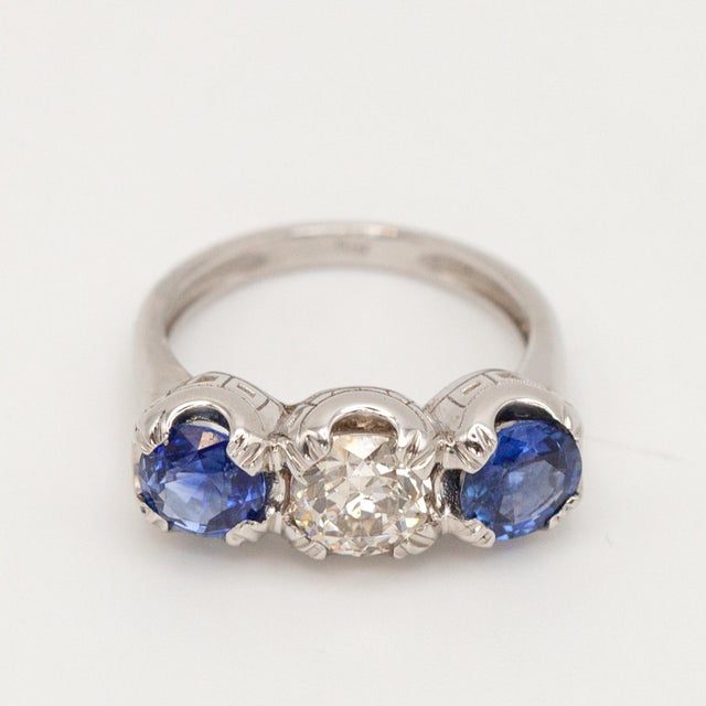 This stunning three-stone ring exquisitely crafted in platinum, set with a sparkling old European cut diamond approximate...