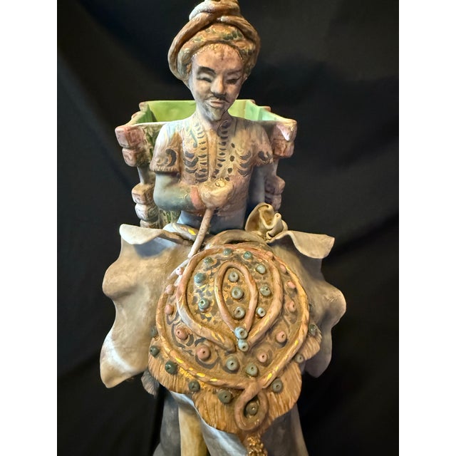 Exquisite mid-20th century hand-painted ceramic elephant planter, featuring a richly adorned elephant carrying an...