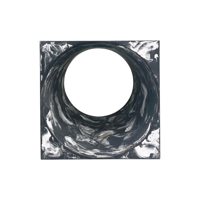 A "Portal" side table produced by the American design company, CB2. Made from marbled resin, this side table features a...