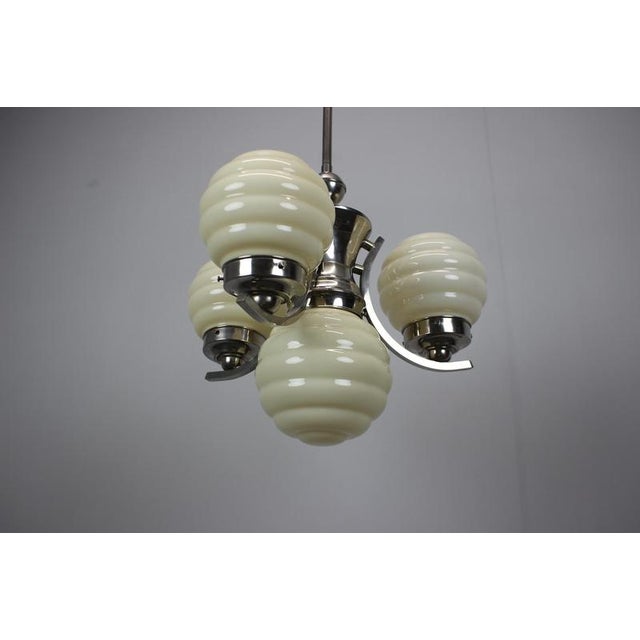 This striking 1930s Art Deco chandelier was produced in Europe, most likely Czechoslovakia, and features for sculptural...