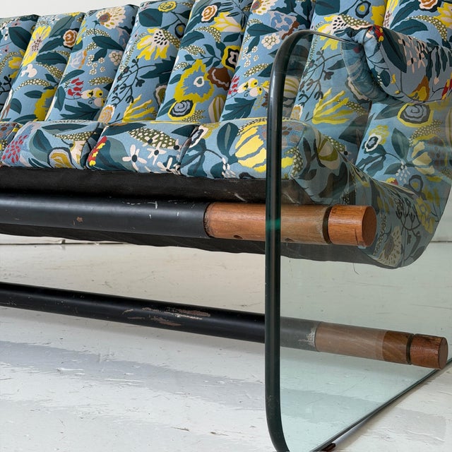 c. 1970s. USA. Walnut end caps with glass legs. Reupholstered in Designtex floral. This piece is attributed to the...