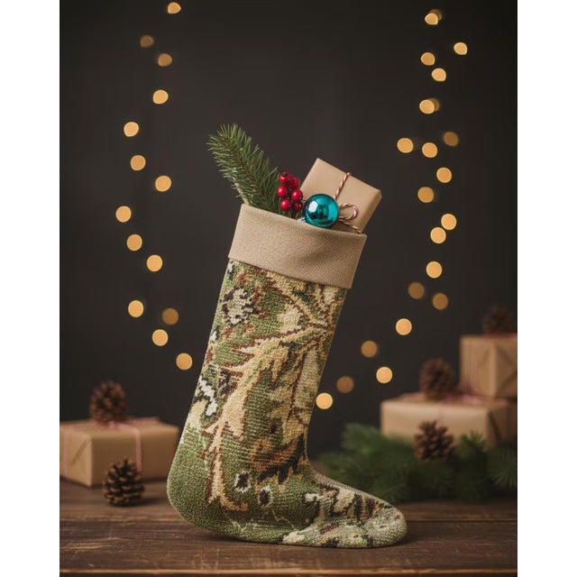 This vintage wool kilim stocking features a rich olive green and golden leaf motif across the body, finished with a...
