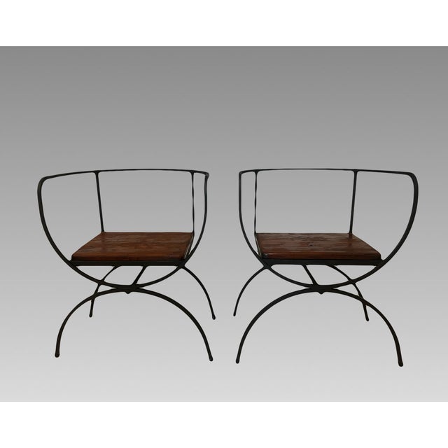 A Pair of Mid Century Modern black wrought iron side / occasional Chairs with solid wood seats. Very minimalist with...