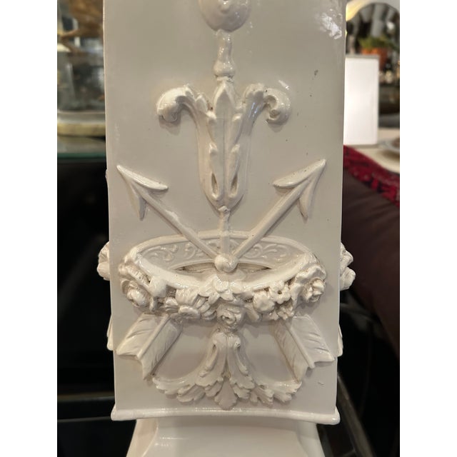 Super glamorous very large white ceramic obelisk table lamp having relief decoration with shell and garlands. Paired with...