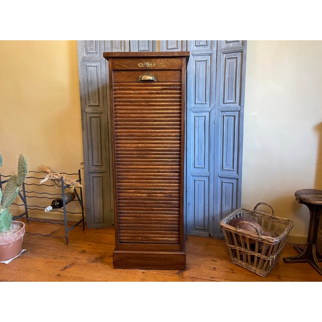 A beautiful and chic French roller shutter cabinet from the early 1900s. The cabinet has a brass handle and fittings....