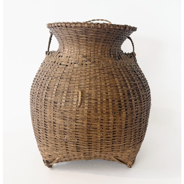 Intricately woven split-bamboo and rattan "alat" basket, crafted as a fish creel. This lovely piece includes the original...