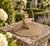 A classic vintage iron garden sundial inspired by traditional English estate landscapes, reading "Grow old along with me....