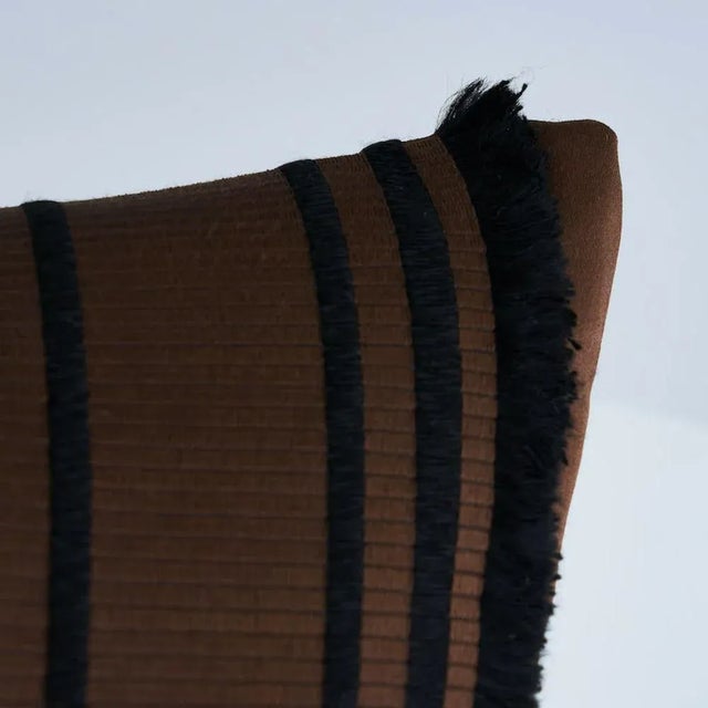 This pillow features Senza Satin Stripe with a knife edge finish. This classic satin stripe features fringed edges for an...