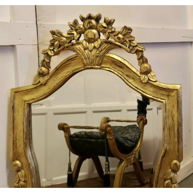 Dramatic Gilt-wood French Wall Mirror The Mirror has a simple carved gilt Frame set with a basket of flowers at the top...