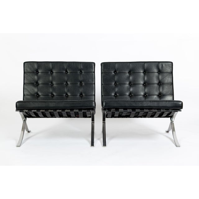 This pair of vintage mid century modern leather Barcelona lounge chairs designed by Mies van der Rohe were manufactured by...
