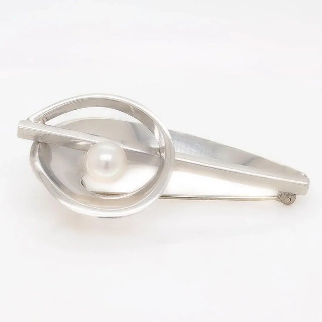 A fine Modernist silver brooch. In sterling 970 silver. By Antonio Pineda. Comprised of looping silver bands reminiscent...