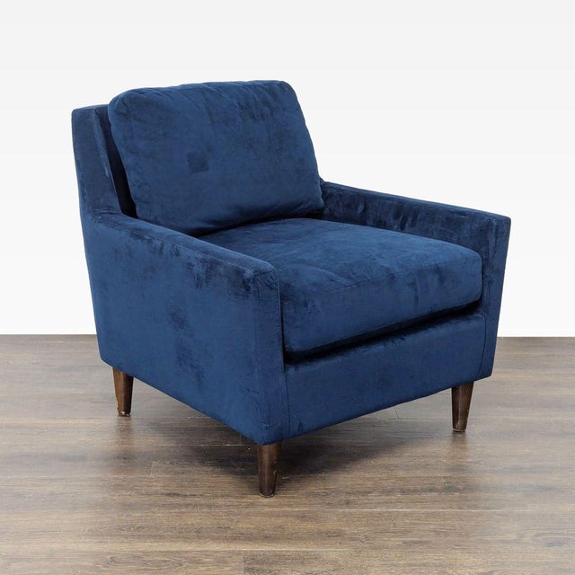 This West Elm lounge chair features a rich blue velvet upholstery and a sleek modern design. With its comfortable...