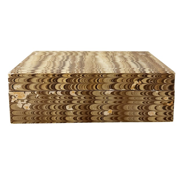 A striking vintage lidded desk or keepsake box crafted from wood and entirely clad in hand-marbled paper, dating to...