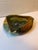 A single triangle shaped art pottery dish with folded sides and raised cow relief design. Finished with green and yellow...