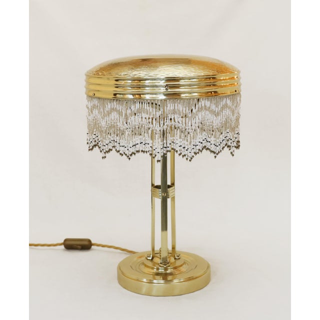 Art Nouveau floor lamp Art Nouveau table lamp, circa 1910. Brass. The shade's top edge is chased and detailed. Glass bead...