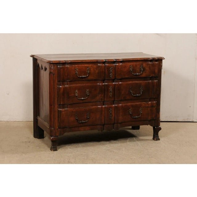 A French Regence period beautifully-carved walnut chest of drawers, with its original hardware, from the 18th century....