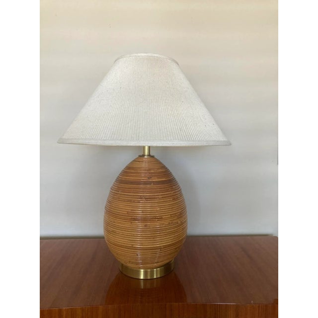 A pear shaped lamp in the style of Gabriella Crespi, c.1970s. It is clad in pencil reed, with a brushed brass base, stem...
