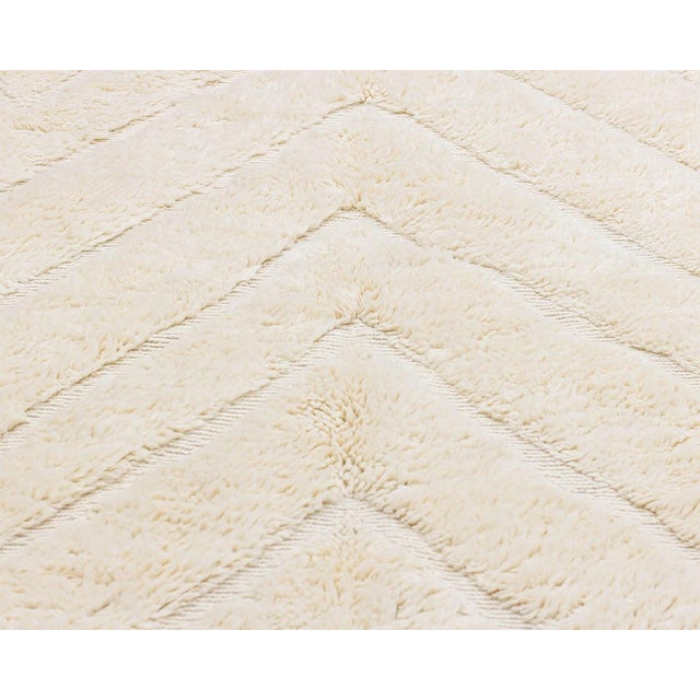 Elegant hand-knotted Ivory natural wool rug showcasing beautiful diamond patterns, which draw inspiration from the rich...