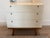 White west elm attributed mid-century modern three-drawer dresser. White lacquer body, pecan base and dark hardware....