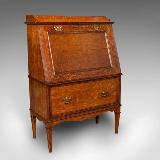 This is an antique metamorphic drinks cabinet. An English, oak bureau form cocktail cabinet, dating to the late Victorian...