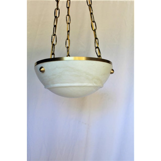 A small size Deco/Modern Chandelier with a solid brass ring applied at the top edge of the Alabaster. Supported by 3...