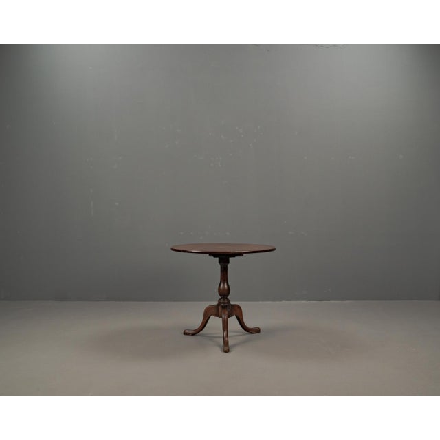 A late 19th century English oak tilting table with a tripod base. The table top can be tilted 90 degrees with a sliding...
