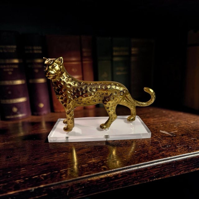 Lovely small brass statue of a leopard on a lucite stand to enhance a shelf or grouping of animal figurines! Very good...