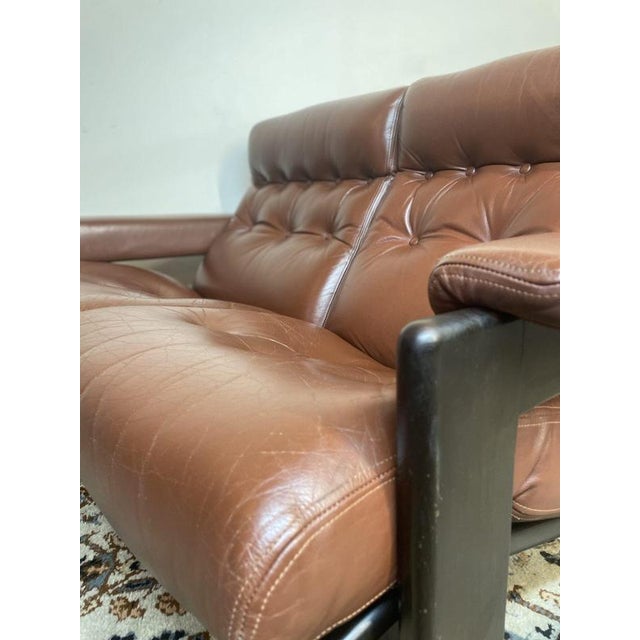 A superb example of mid-century scandinavian craftsmanship, this elegant buttoned-back two-seater sofa is finished in...