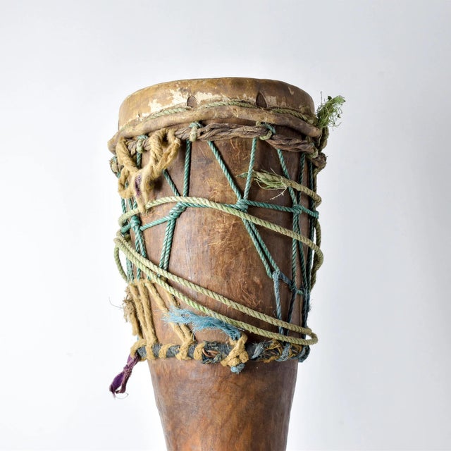 This drum is tied around the waist by the strings and played. The strings are new and replaced often. The drum is old and...