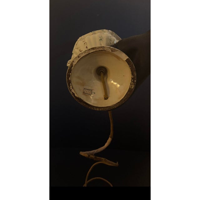 Decorative porcelain table lamp, featuring floral decorations with scroll handles.