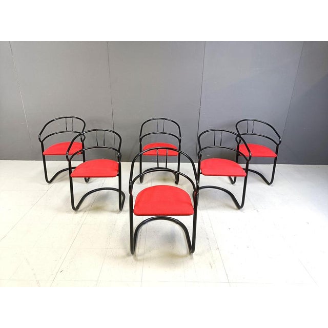 Post modern design dining chairs by Vepa, Netherlands. They feature a black metal frame and red fabric seats. 1980s -...