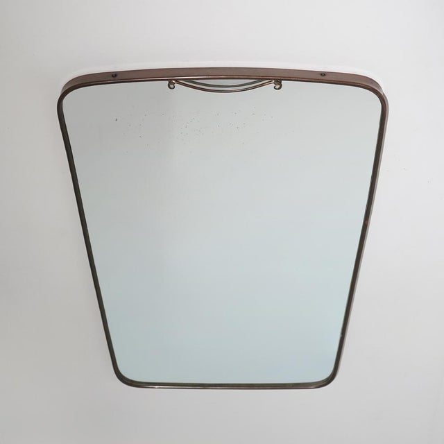 A wall mirror from the 1950s characterised by a brass frame with a rectangular shape and rounded corners. The design is...