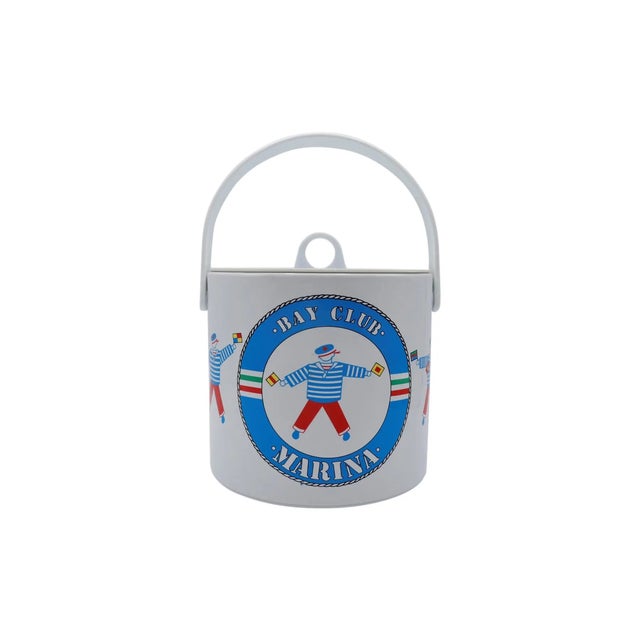 A nautical themed ice bucket in red, white and blue. The lid is white and lifts off with a white handle. The bucket is...