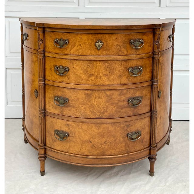 Here is a gorgeous, statement Demi-lune chest of drawers/cabinet featuring carved wood columns and burled wood drawer...