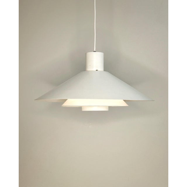 This sculptural pendant lamp is crafted in lacquered steel with a characteristic multi-layered shade construction designed...