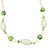 The necklace is composed of finely carved ivory-toned "ivorine" glass beads interspersed with vibrant leaf-green glass...
