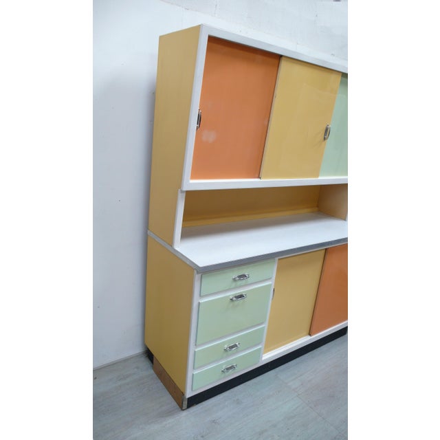 1950s kitchen cabinet with vibrant colors. 3 sliding doors at the top and 2 at the bottom, bread compartment, 3 drawers, 6...